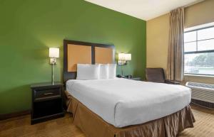 a hotel room with a large bed and a window at Extended Stay America Select Suites - Chicago - O'Hare in Rosemont