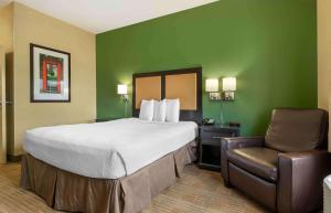 a hotel room with a bed and a chair at Extended Stay America Select Suites - Chicago - O'Hare in Rosemont