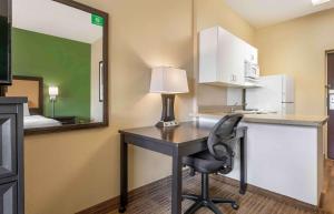 a desk with a lamp and a chair in a room at Extended Stay America Select Suites - Chicago - O'Hare in Rosemont