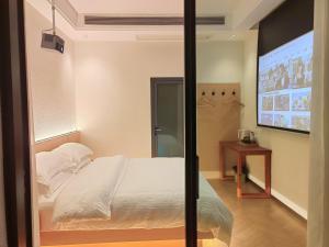 a bedroom with a white bed and a screen at Flower Whisperer Homestay in Zhangjiajie