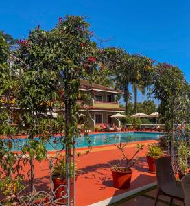 une piscine avec des arbres et des plantes en face d'un complexe dans l'établissement Skylark Resort, à Colva