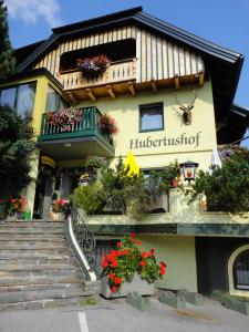 un edificio con flores y plantas delante de él en Landgasthof Hubertusstubn, en Sankt Michael im Lungau