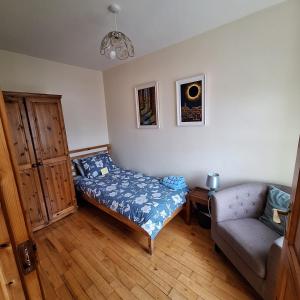 een slaapkamer met een bed, een bank en een stoel bij Lovely Single Room in Listowel Kerry in Listowel