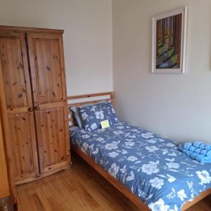 een kleine slaapkamer met een bed en een kast bij Lovely Single Room in Listowel Kerry in Listowel