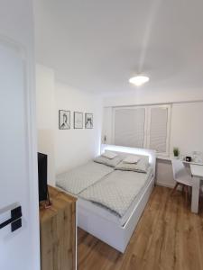 ein weißes Schlafzimmer mit einem Bett und einem Schreibtisch in der Unterkunft Apartament in Ostrołęka