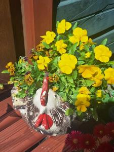 uma estátua de pássaro sentada ao lado de um ramo de flores amarelas em CasaVerde Hostal Ecologico em Malalcahuello