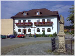 a large white building with a statue in front of it at Hotel Stara Skola in Sloup