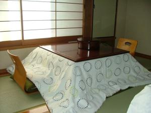 een bed met een tafel in een kamer bij Miyajima Hotel New Kotobuki in Miyajima