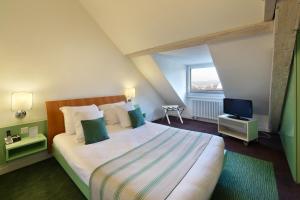 a bedroom with a large bed and a television at Hotel International & Terminus in Geneva