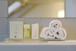 a pile of towels on a shelf in a bathroom at Hotel International & Terminus in Geneva