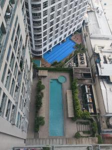 un bâtiment avec une piscine en face d'un grand bâtiment dans l'établissement Soho Central Residences, à Manille