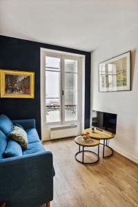 - un salon avec un canapé bleu et une table dans l'établissement BnBNova - 1BR - Invalides & Tour Eiffel, à Paris