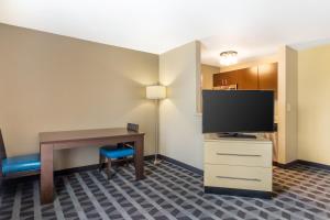 een hotelkamer met een bureau en een flatscreen-tv bij MainStay Suites Houston NASA-Clear Lake in Webster