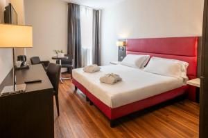 A bed or beds in a room at Kona Hotel Verona by Kleos Group Collection