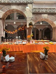 una mesa larga con platos de comida. en Waman Qorikancha, en Cusco