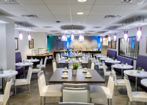 a dining room with tables and white chairs at Kellogg Conference Hotel Capitol Hill at Gallaudet University in Washington