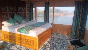 een bed in een kamer met een groot raam bij The Smith Palace Group Of HouseBoats in Srinagar