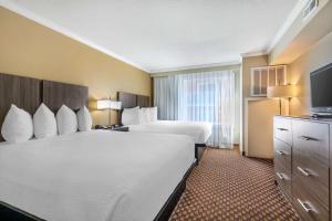 um quarto de hotel com duas camas e uma televisão em Best Western Ocean City Hotel and Suites em Ocean City