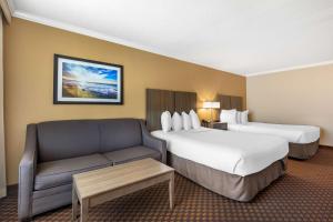 um quarto de hotel com duas camas e um sofá em Best Western Ocean City Hotel and Suites em Ocean City