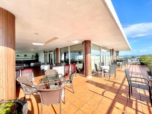 un patio al aire libre con sillas y mesas en el balcón en Mondial Hotel Hue, en Hue