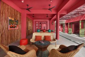 een woonkamer met roze muren en een tafel en stoelen bij PinkCoco Gili Trawangan - Constant Surprises - for Cool Adults Only in Gili Trawangan