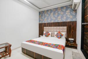 ein Schlafzimmer mit einem weißen Bett und einer blauen Wand in der Unterkunft FabHotel Elvis Inn - Nr Mumbai International Airport in Mumbai