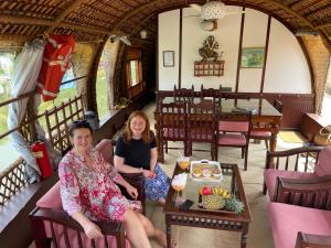 Due donne sedute in una stanza in un treno di Thara's Houseboat a Alleppey