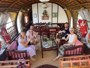 un gruppo di persone seduti su sedie in una stanza di Thara's Houseboat a Alleppey