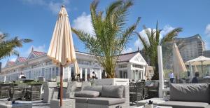 un patio con sillas y sombrillas frente a un edificio en Grand Hotel Huis ter Duin, en Noordwijk aan Zee