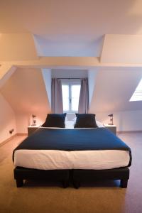 a bedroom with a large bed in front of a window at Hotel Neuvice in Liège