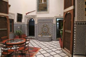 cortile con tavolo, sedie e fontana di Riad Rayhana a Fes