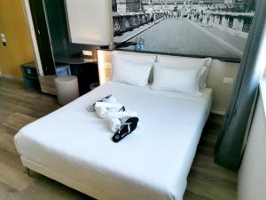 菲乌米奇诺B&B Hotel Roma Fiumicino Aeroporto Fiera 1的一张白色的床,上面有一双鞋