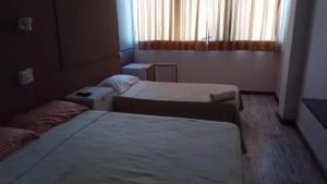 a hotel room with two beds and a window at cronos hotel in Villa Carlos Paz