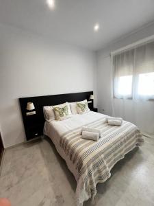 博尔穆霍斯LuxSevilla Moderno 1 Room Piscina Parking的一间卧室配有一张大床和两个枕头