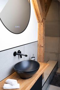 lavabo de tazón negro en una encimera de madera en el baño en Stilvolle Maisonette in Lüneburg - Free parking, Kreidebergsee, Zentrumsnah, en Lüneburg