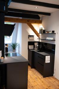 una cocina con encimeras negras y una ventana grande en Stilvolle Maisonette in Lüneburg - Free parking, Kreidebergsee, Zentrumsnah, en Lüneburg