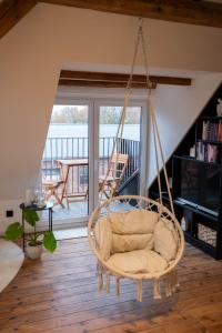 una silla mecedora en una sala de estar con balcón en Stilvolle Maisonette in Lüneburg - Free parking, Kreidebergsee, Zentrumsnah, en Lüneburg