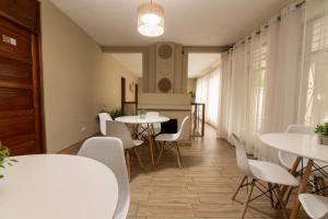 une salle à manger avec des tables et des chaises blanches dans l'établissement In & Out Hotel, à Guatemala