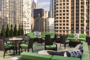 een dakterras met groene stoelen en tafels en gebouwen bij The Royal Sonesta Chicago River North in Chicago