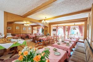 un restaurante con mesas y sillas con manteles rosados en Pension Sonneneck, en Bayerisch Eisenstein