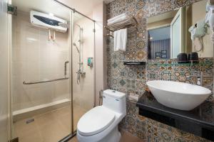 a bathroom with a toilet and a sink and a shower at Charlie House Hanoi in Hanoi