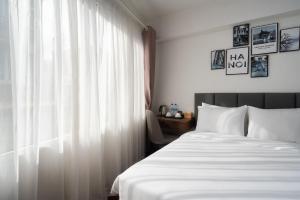 a bedroom with a white bed and a window at Charlie House Hanoi in Hanoi