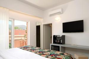 a bedroom with a bed and a flat screen tv at High Beach Resort in Malia