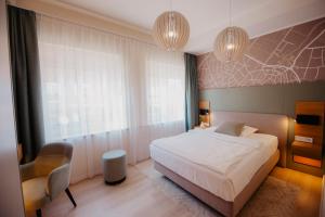 a bedroom with a large white bed and a chair at Hotel-Restaurant Haselhoff in Coesfeld