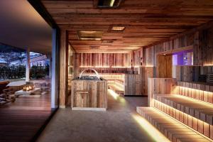 Habitación con paredes de madera y cocina con encimera. en Der Böglerhof - pure nature spa resort, en Alpbach