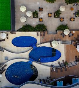 una vista sul tetto di tre piscine con acqua blu di Foz Plaza Hotel a Foz do Iguaçu