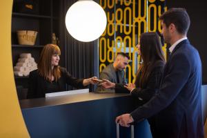 Un groupe de personnes debout autour d'un comptoir dans l'établissement Num Hotel, à Salou