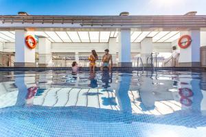 un groupe de personnes debout dans une piscine dans l'établissement Num Hotel, à Salou