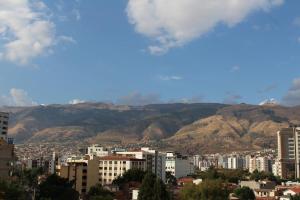 a city with buildings and mountains in the background at Kunan Hotel in Cochabamba