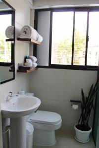 a bathroom with a sink and a toilet and windows at Kunan Hotel in Cochabamba